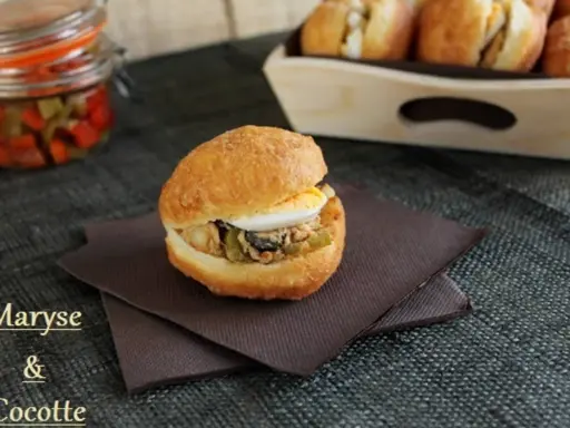 Un délicieux fricassé tunisien garni d'œuf dur, de thon et de légumes croquants, prêt à être dégusté.