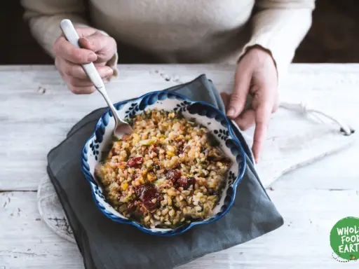 Un bol de freekeh recette, garni de canneberges et de légumes, prêt à être dégusté.