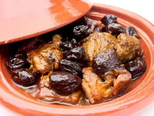 Un plat de tajine aux pruneaux, avec des morceaux de viande mijotés dans une sauce onctueuse et des pruneaux moelleux.