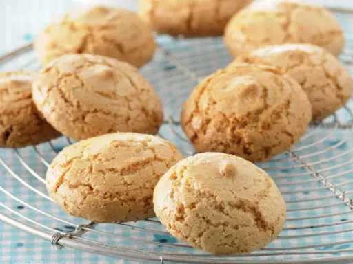 Amaretti dorés et craquelés sur une grille, prêts à être dégustés. Une recette facile pour un plaisir gourmand.