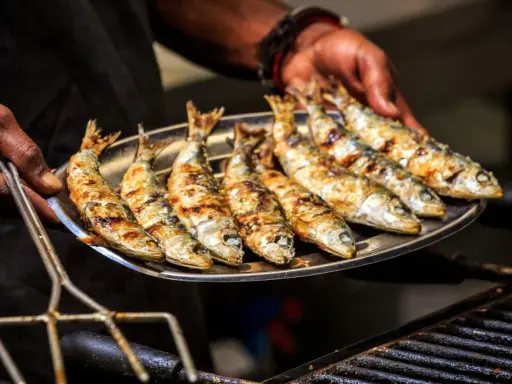 Une assiette de sardines grillées, dorées et savoureuses, prêtes à être dégustées.