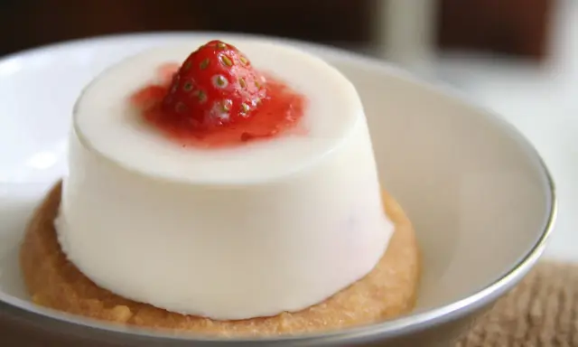Panna cotta à la fraise sur un biscuit. Si elle est trop liquide, pas de panique, voici comment rattraper une panna cotta trop liquide.