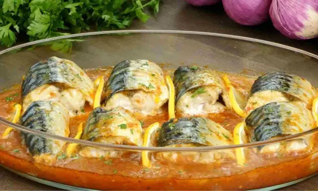 Délicieux maquereau au four, baignant dans une sauce tomate savoureuse, garni de rondelles de citron et de persil frais.