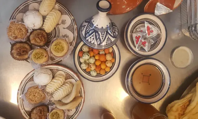 Assortiment de pâtisseries orientales, parfait pour une recette marocaine. Des biscuits, des nids de pistaches, des fruits secs et des bonbons colorés.