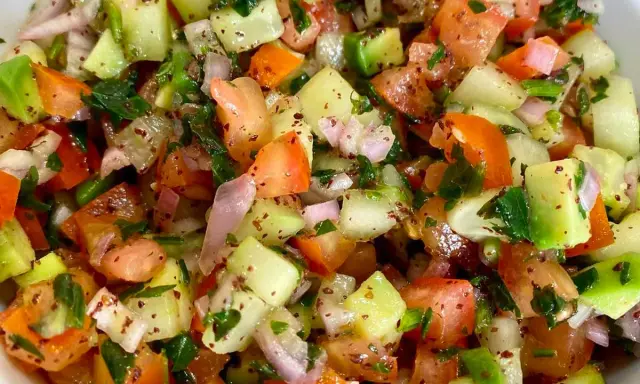 Salade marocaine fraîche et colorée, mélange de tomates, concombres, oignons rouges et persil, assaisonnée d'épices.