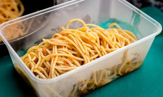 Boîte transparente remplie de spaghettis à la sauce bolognaise, idéale pour la conservation des pâtes cuites.
