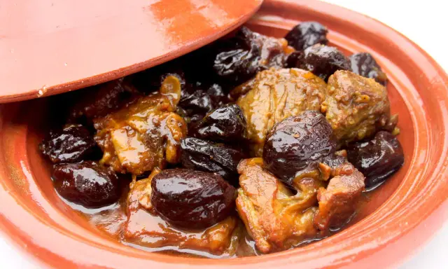 Un plat de tajine aux pruneaux, avec des morceaux de viande mijotés dans une sauce onctueuse et des pruneaux moelleux.