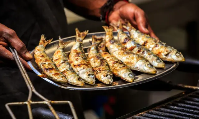 Une assiette de sardines grillées, dorées et savoureuses, prêtes à être dégustées.