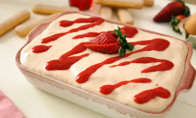 Tiramisu fraise crémeux, avec 500g de mascarpone, garni de coulis de fraises et d'une fraise fraîche.