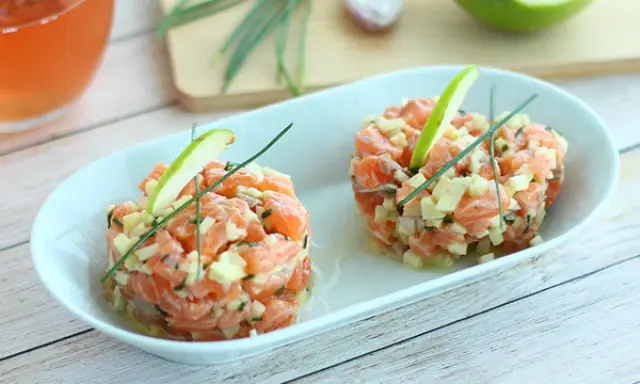 Deux tartares de saumon frais, garnis de dés de pomme verte et de ciboulette, parfaits pour une recette saumon fumé revisitée.