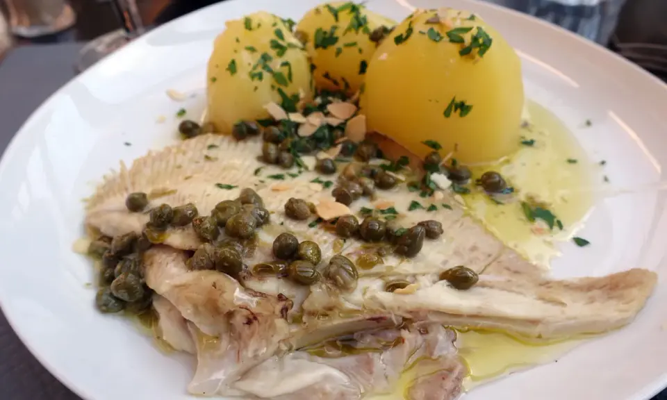 Une aile de raie poêlée, nappée de sauce aux câpres et amandes, accompagnée de pommes de terre vapeur. Une recette simple et savoureuse.