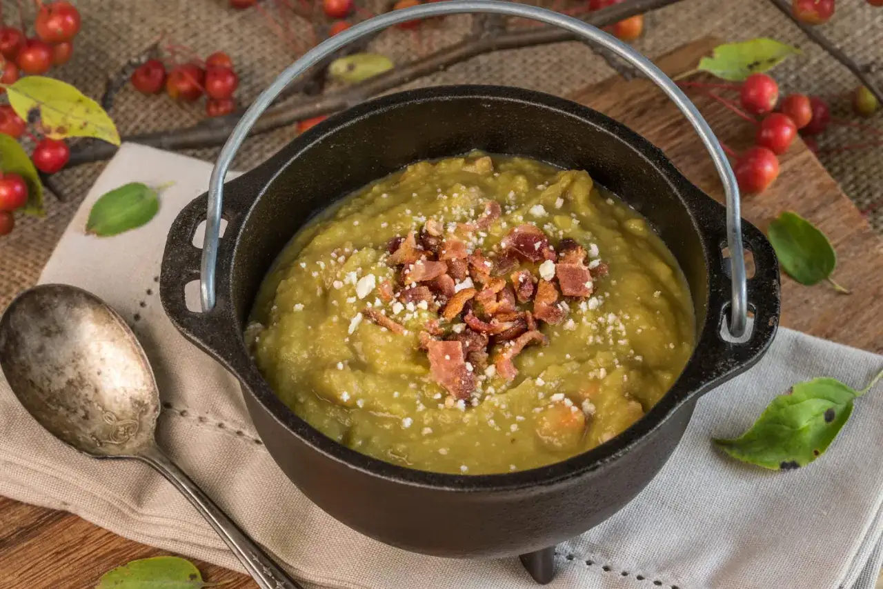 Un chaudron de pois cass&eacute;s cr&eacute;meux, garni de lardons croustillants et de fromage r&acirc;p&eacute;, pr&ecirc;t &agrave; &ecirc;tre d&eacute;gust&eacute;.