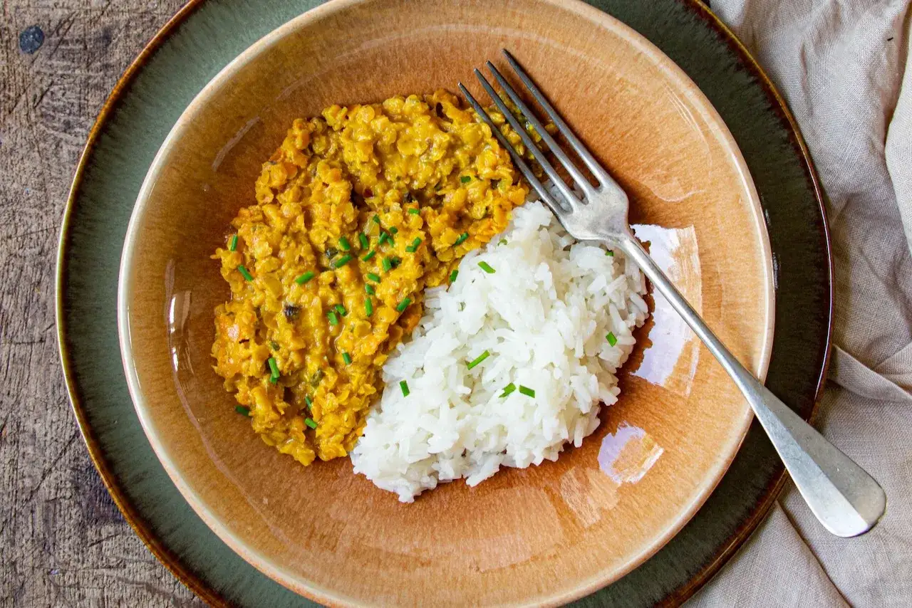 Un plat r&eacute;confortant de riz blanc et de lentilles corail &eacute;pic&eacute;es, garni de ciboulette fra&icirc;che. Un d&eacute;lice simple et savoureux.