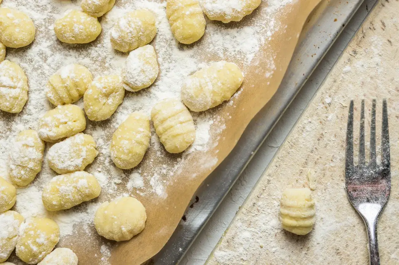 Gnocchis faits maison, pr&ecirc;ts pour la cuisson. Une fourchette &agrave; c&ocirc;t&eacute; sugg&egrave;re la prochaine &eacute;tape de cette recette gnocchi.