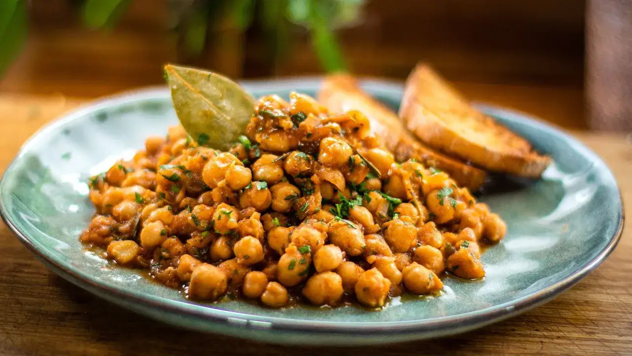 Délicieux pois chiches mijotés, parfumés d'herbes et d'une feuille de laurier, accompagnés de toasts grillés. Une belle cuisson pois chiche.