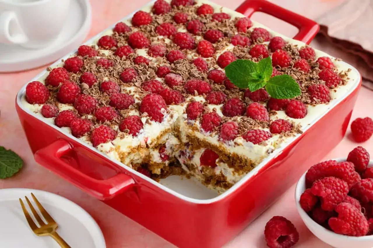 Un d&eacute;licieux tiramisu framboise garni de fruits rouges frais et de copeaux de chocolat, pr&ecirc;t &agrave; &ecirc;tre d&eacute;gust&eacute;.