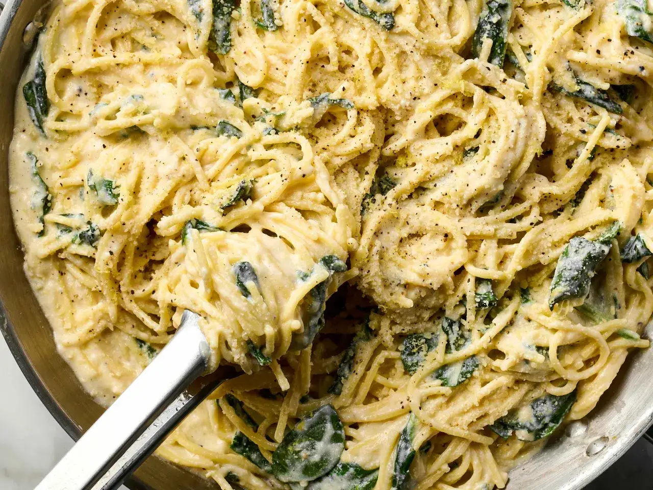 Spaghetti cr&eacute;meux &agrave; la ricotta et aux &eacute;pinards, parsem&eacute; de parmesan et de poivre noir. Une recette facile et savoureuse.