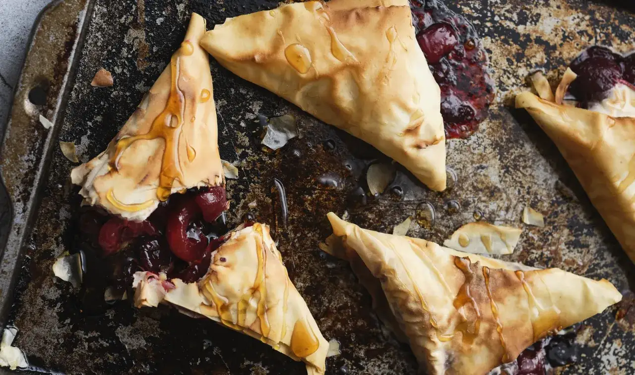 Triangles de p&acirc;te filo croustillante, garnis de cerises juteuses et napp&eacute;s de miel. Une d&eacute;licieuse recette sal&eacute;e avec p&acirc;te filo, parfaite pour un ap&eacute;ritif gourmand.