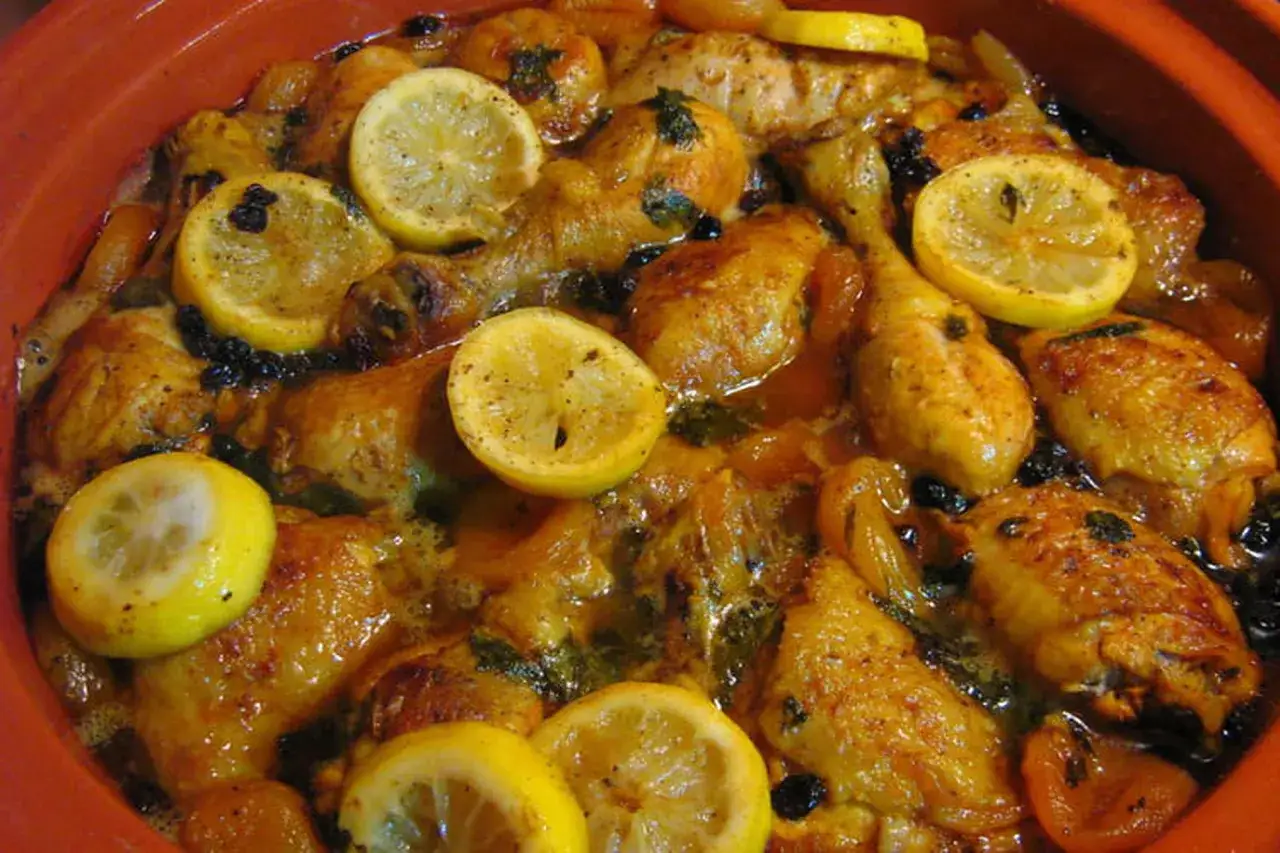Un plat de tajine poulet citron, aux morceaux de poulet dor&eacute;s, parsem&eacute; de rondelles de citron, de raisins secs et d'abricots secs.