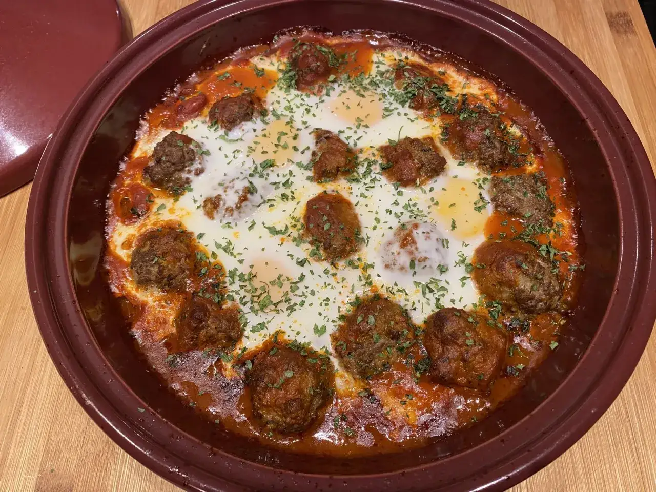 Un plat de tajine kefta aux &oelig;ufs poch&eacute;s, garni de persil frais. Un d&eacute;lice marocain pr&ecirc;t &agrave; &ecirc;tre d&eacute;gust&eacute;.