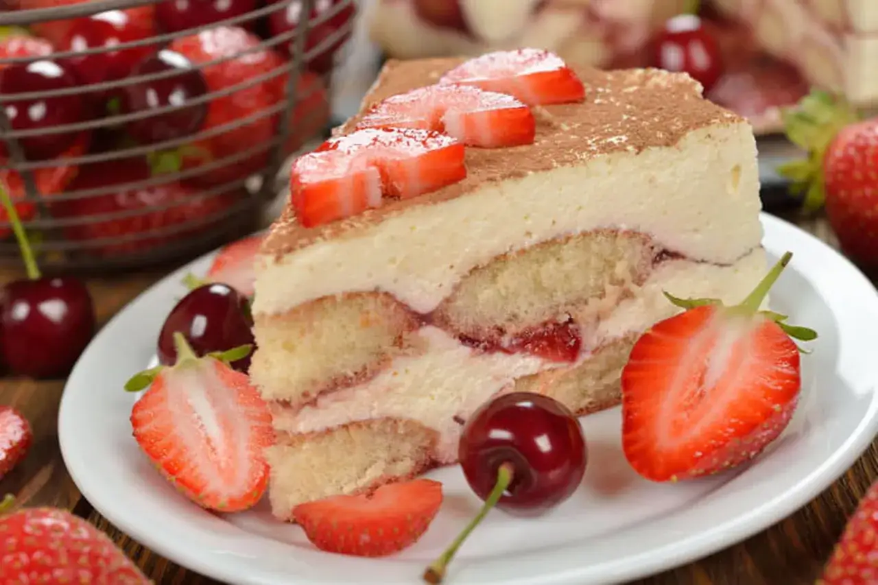 Tranche de tiramisu fraise, aérien et crémeux, avec 500g de mascarpone, garni de fruits rouges frais.