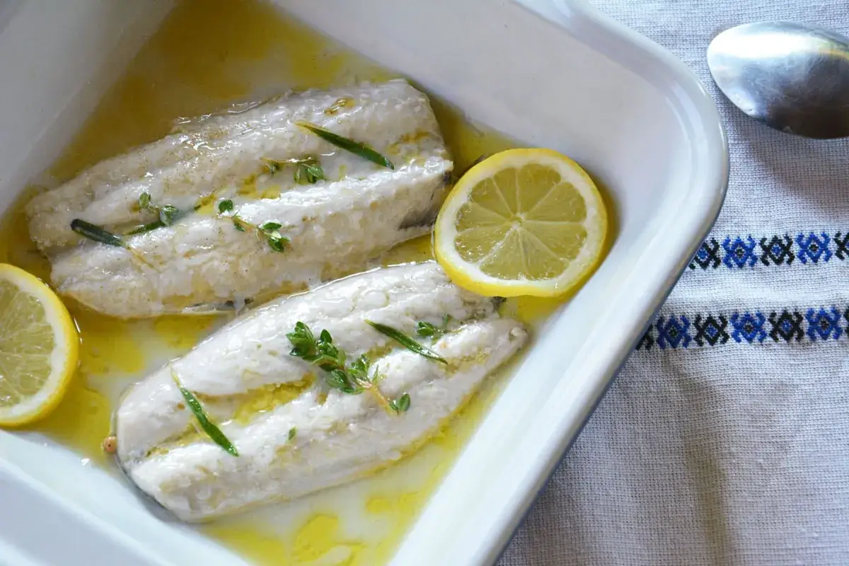 Deux filets de maquereau au four, nappés d'une sauce dorée, ornés de thym et de rondelles de citron. Un délice simple et savoureux.