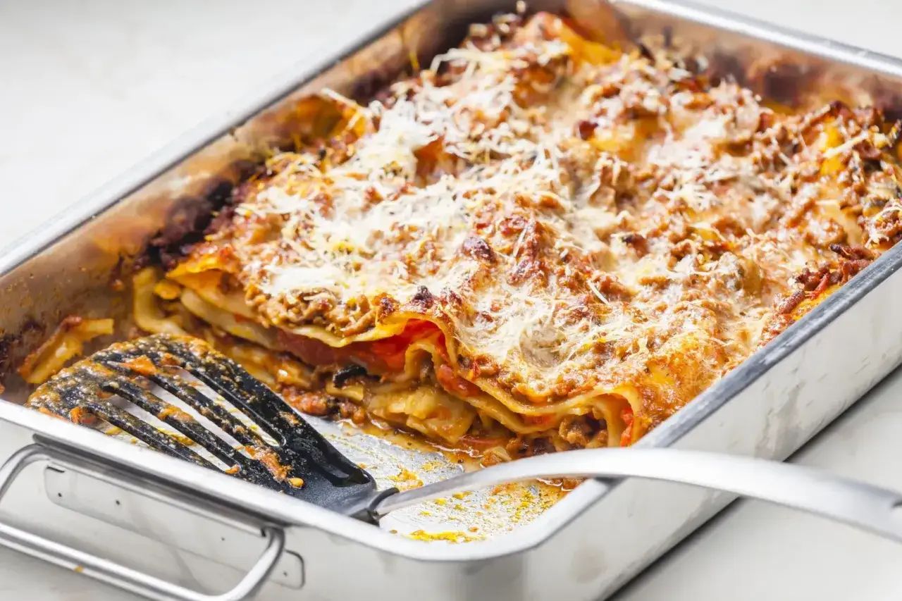 Lasagne maison dor&eacute;e et gratin&eacute;e, pr&ecirc;te &agrave; &ecirc;tre servie. Un plat g&eacute;n&eacute;reux pour lasagne 8 personnes, avec une spatule pour servir.