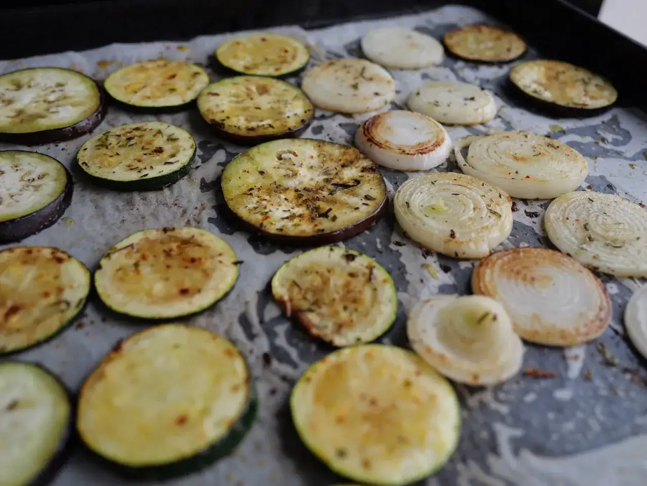 Tranches d'aubergines et d'oignons assaisonn&eacute;es, pr&ecirc;tes pour une d&eacute;licieuse recette plancha.