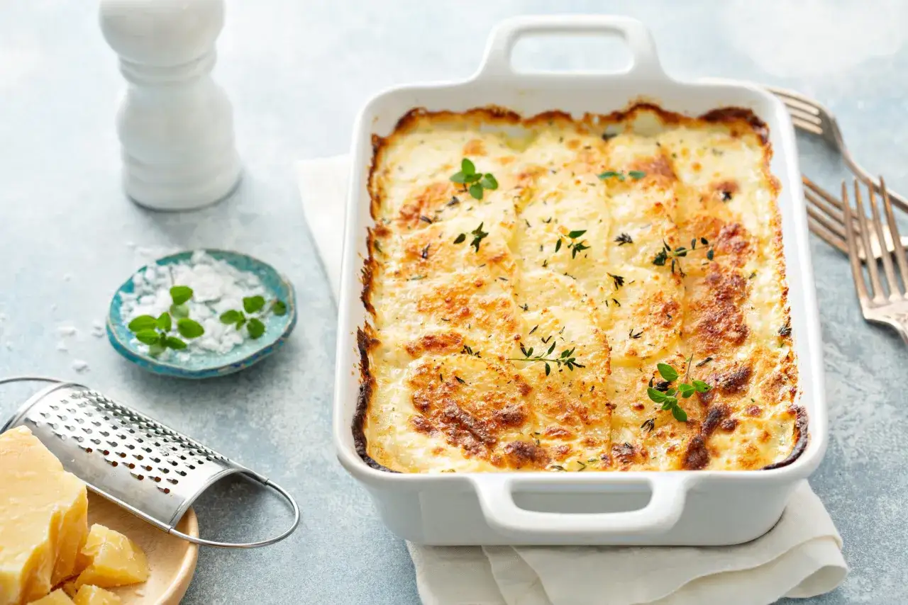 Gratin de pommes de terre dor&eacute;, une lasagne sans b&eacute;chamel avec cr&egrave;me fra&icirc;che, garnie d'herbes fra&icirc;ches.