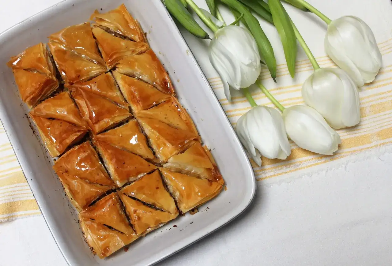 Un plat de baklava dor&eacute; et sirupeux, pr&ecirc;t &agrave; &ecirc;tre d&eacute;gust&eacute;. Une recette parfaite pour les gourmands.