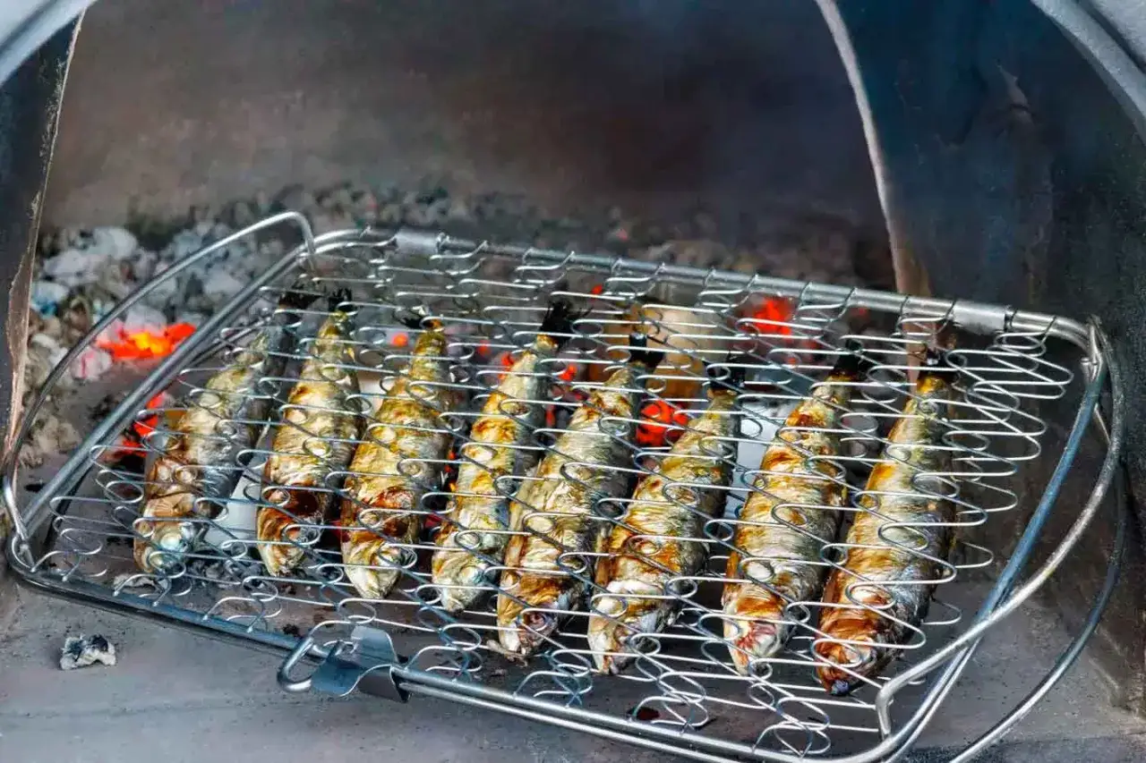 Sardines grillées sur un barbecue, leur peau dorée par la chaleur des braises. Un délice simple et savoureux.