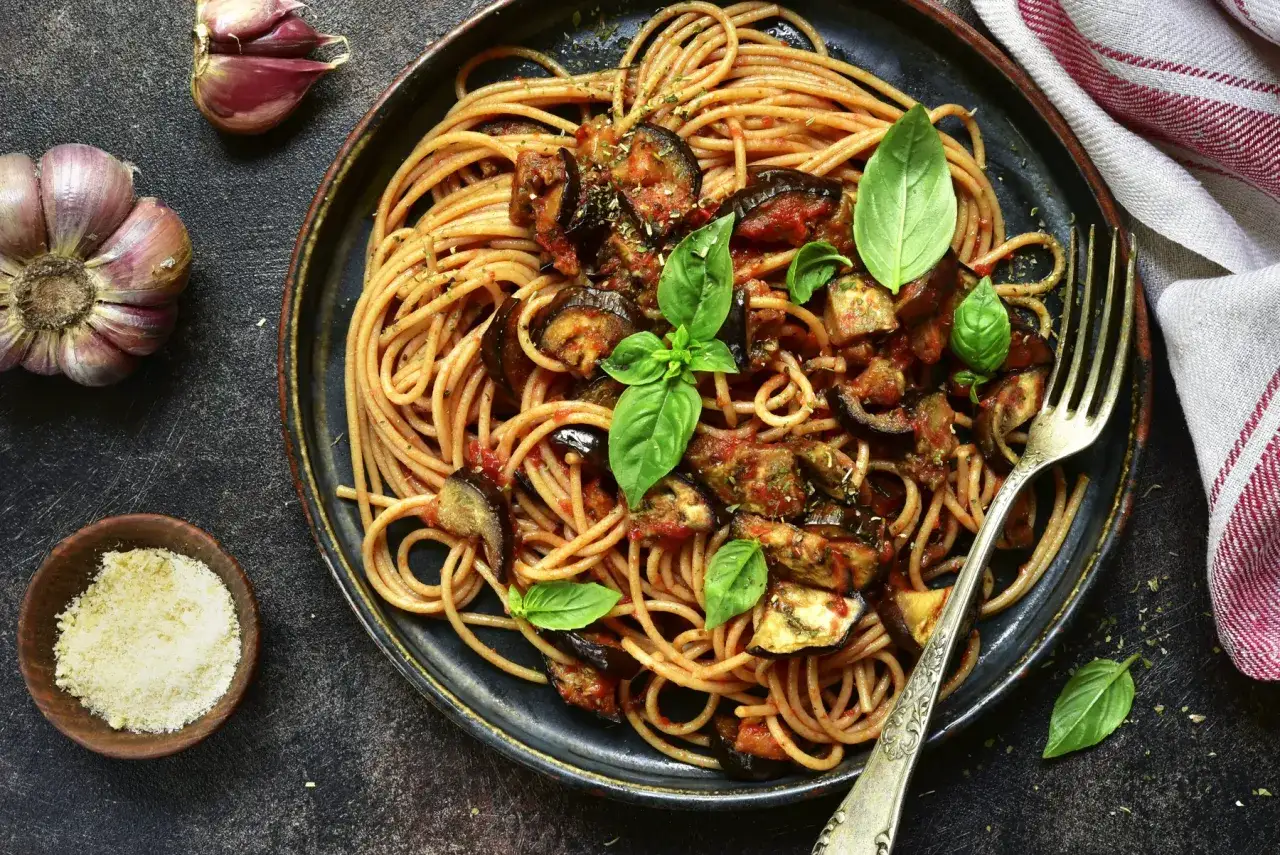 D&eacute;licieuse recette p&acirc;te aux l&eacute;gumes italienne : spaghetti avec aubergines, tomates et basilic frais. Un plat savoureux et color&eacute;.