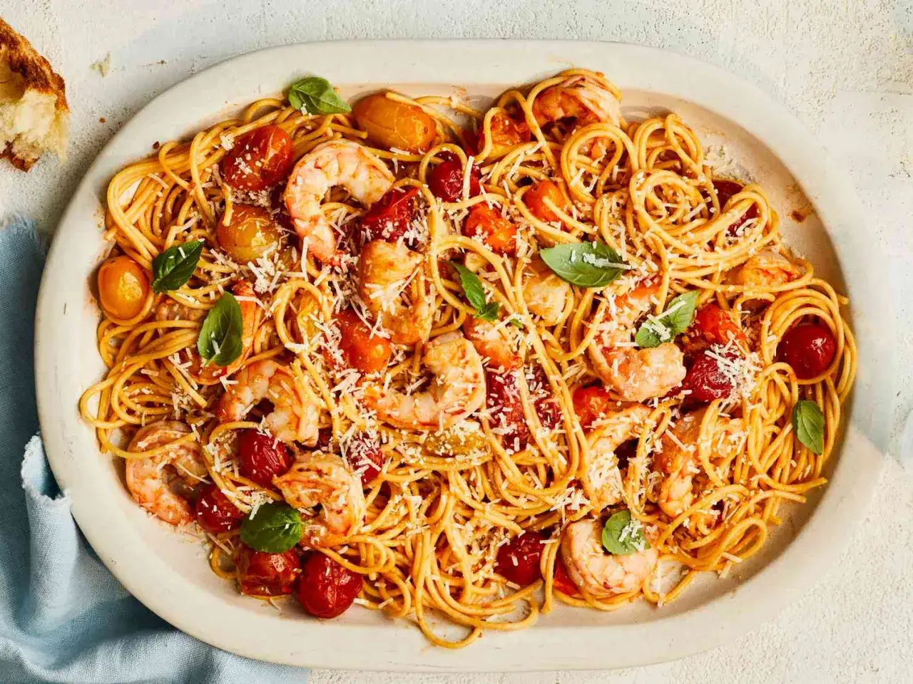 D&eacute;licieuses p&acirc;tes aux crevettes, une recette italienne savoureuse avec tomates cerises et basilic frais, saupoudr&eacute;e de parmesan.